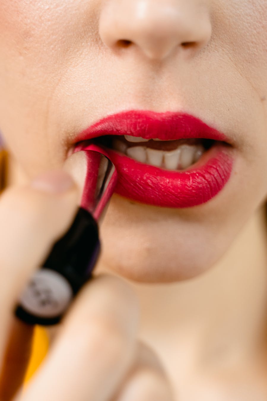 Red lipstick application close-up
